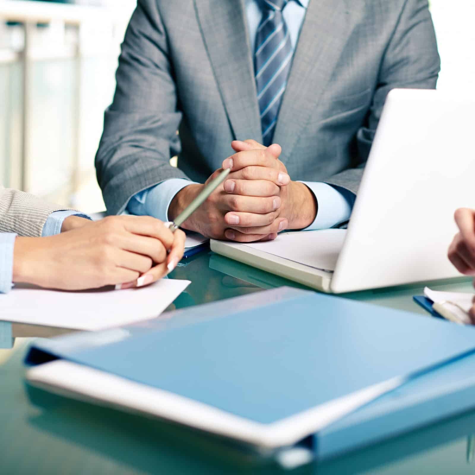 Close-up of hands of boss at workplace with laptop and hands of two females near by